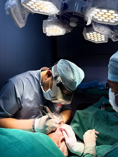 Dr. Atul Bhanu Singla placing grafts under loupes in theatre